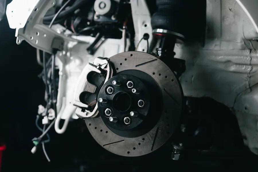 Close-up of a vented brake rotor and caliper during a brake service