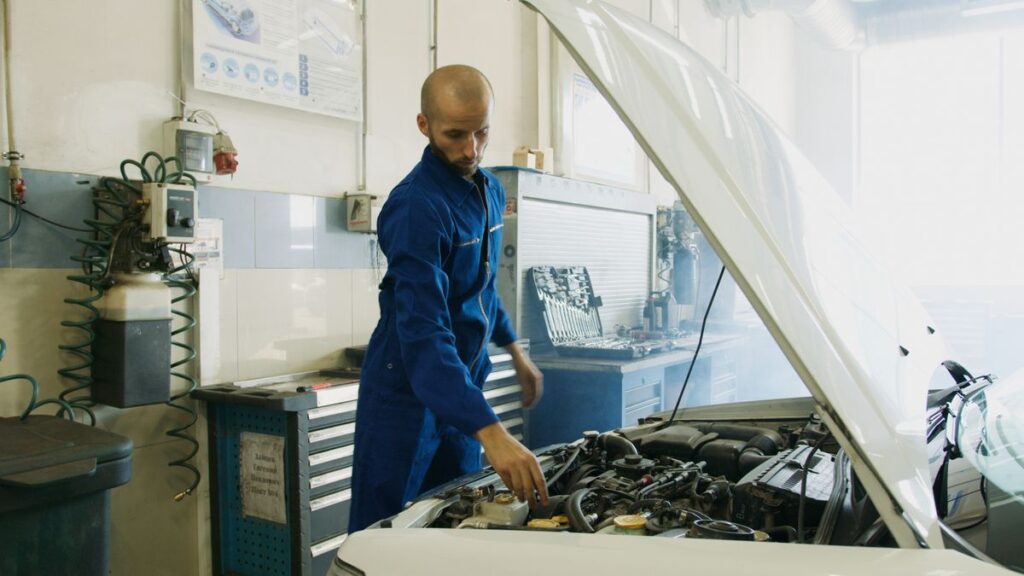 Mechanic working in an engine bay in a workshop