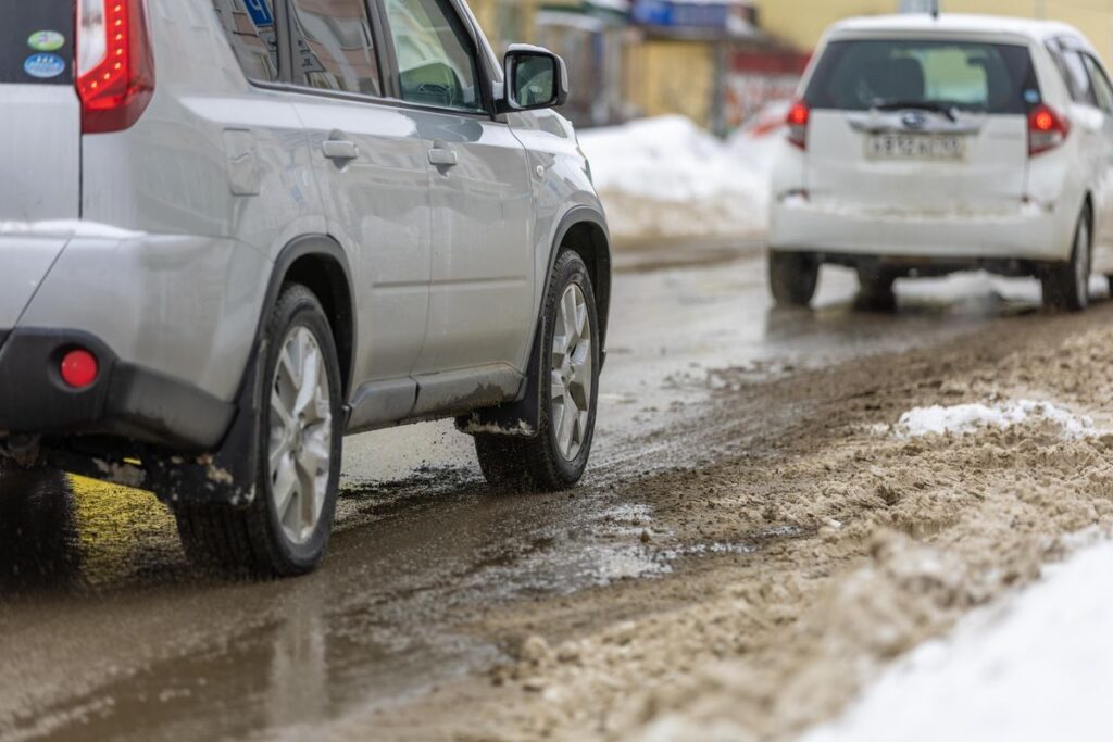Cars driving on a slushy salted road in winter