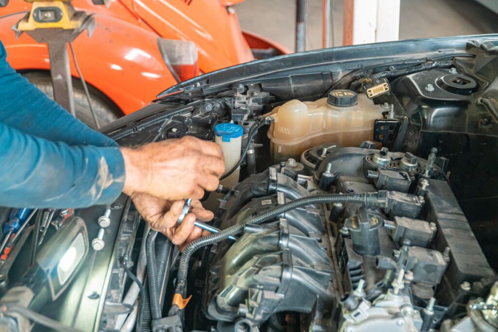 Mechanic's hands working in an engine bay