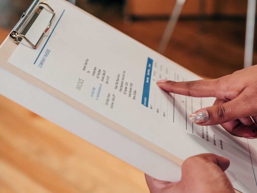 Hand pointing to a service form on a clipboard