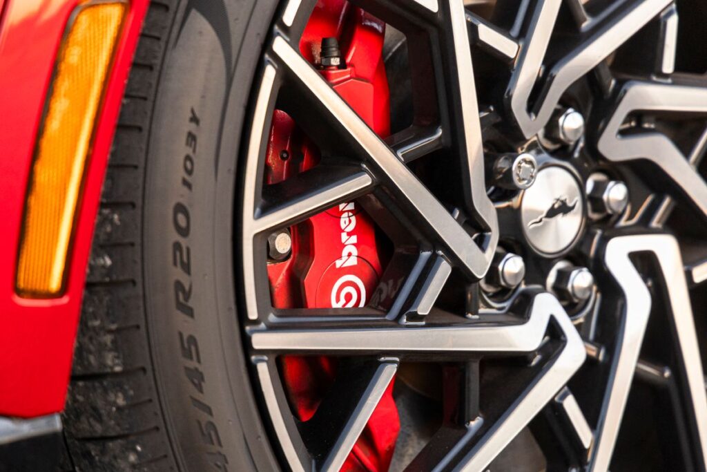 Red brake caliper behind an alloy wheel