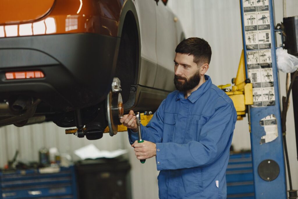 Mechanic working on a wheel hub with the car on a lift