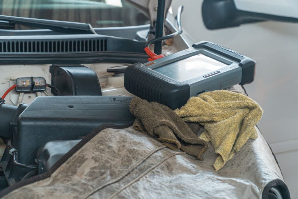 Diagnostic scan tool resting on an engine