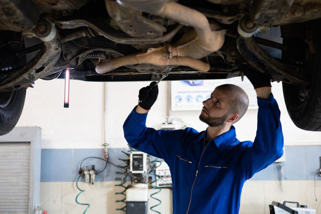 Mechanic inspecting the underside of a car on a lift