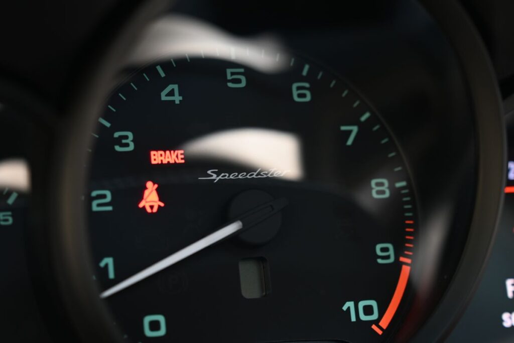 Speedometer showing brake and seatbelt warning lights