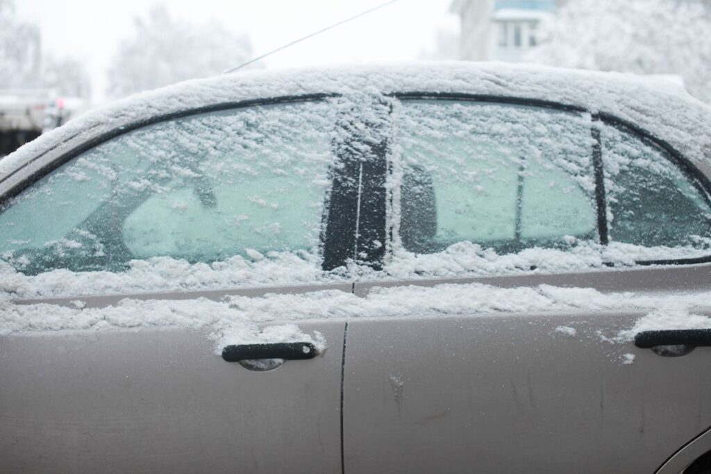 Snow-covered car doors and windows