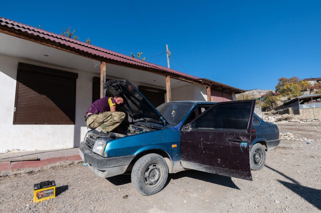 Man working under the hood of an old car