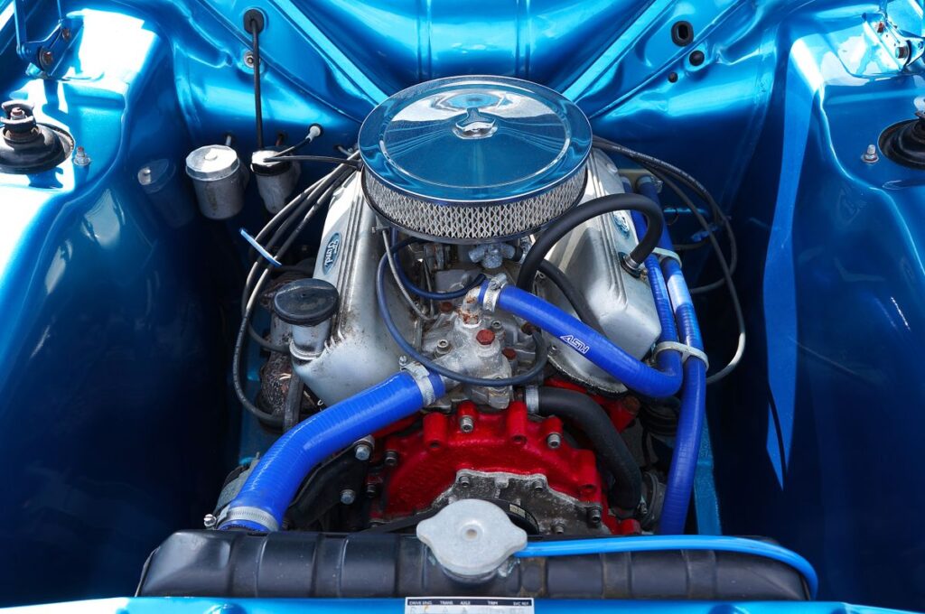 Engine bay with a chrome air cleaner and blue hoses