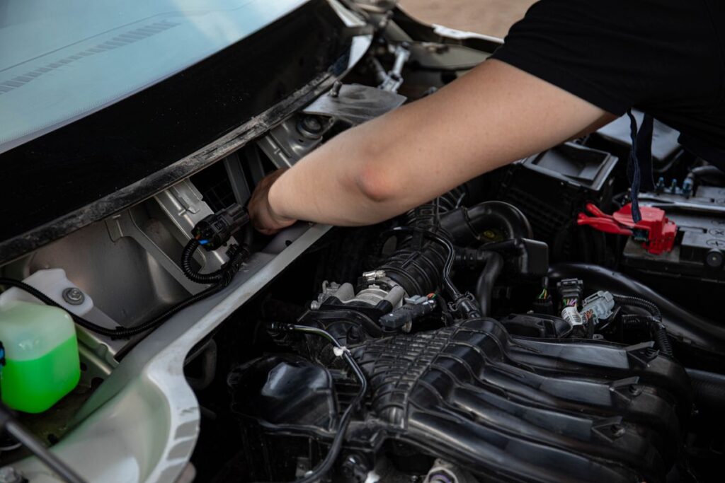 Hands working in an engine bay
