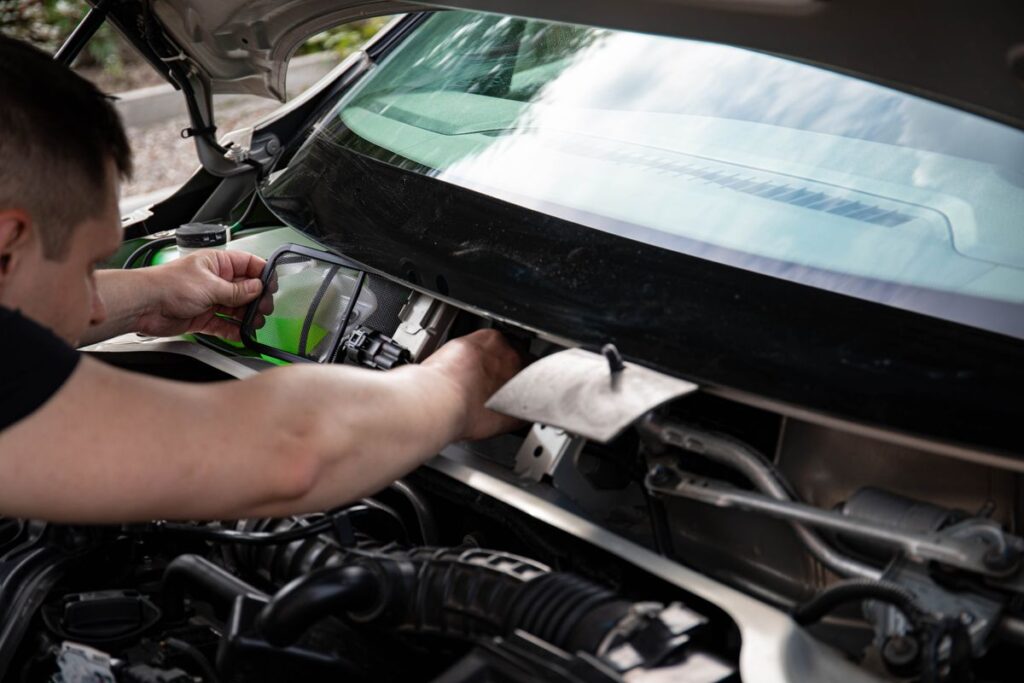 Mechanic reaching into an engine bay