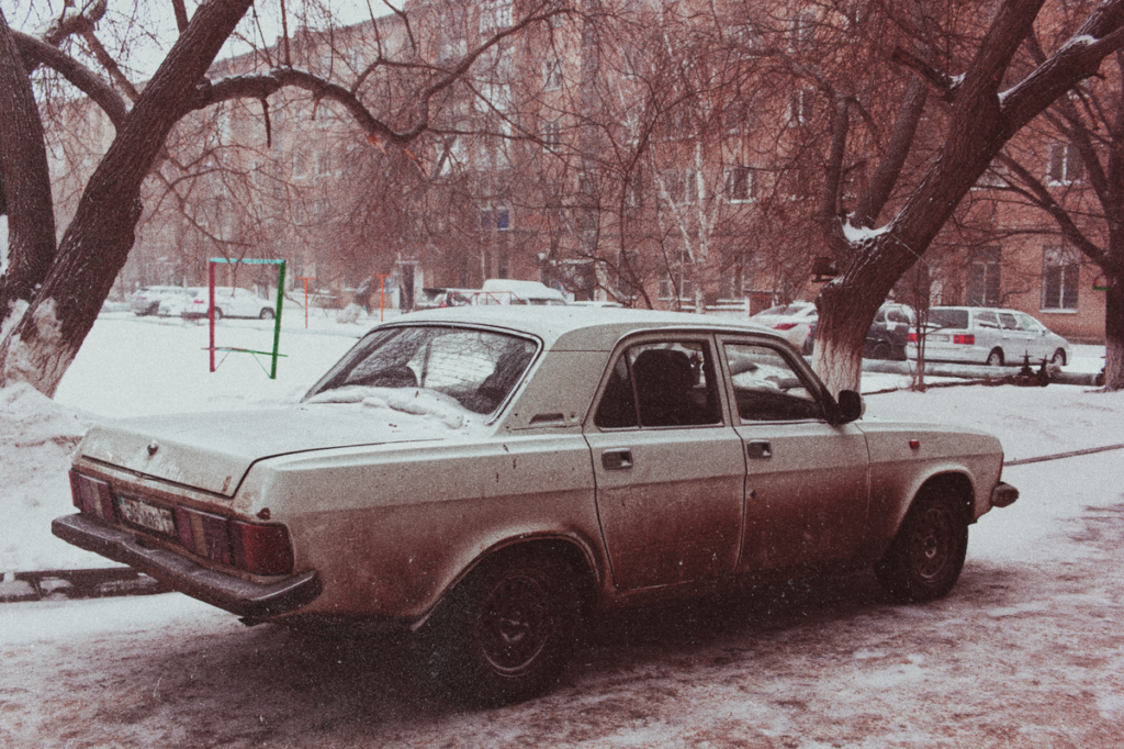 Old sedan parked in snow