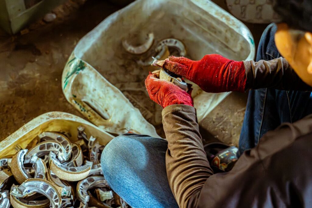 Gloved hands sorting brake shoes