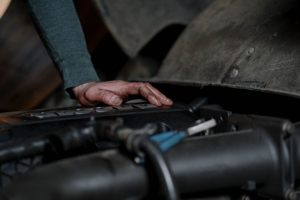 Hand on top of an engine in an engine bay