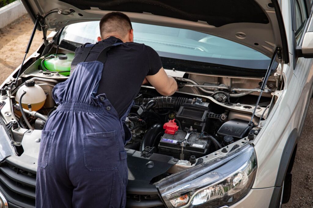 Mechanic leaning into an open engine bay