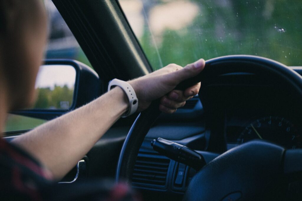 Driver's hand on a steering wheel while driving