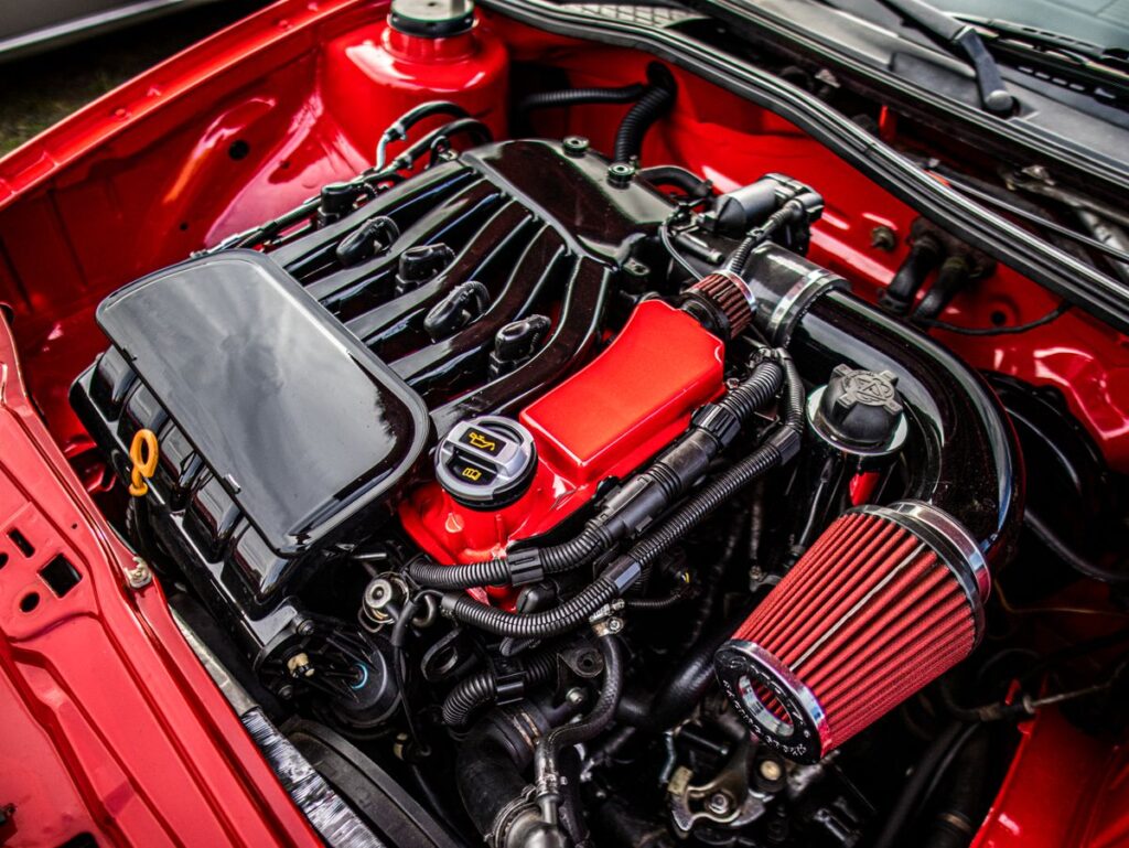 Engine bay of a red car with the hood open