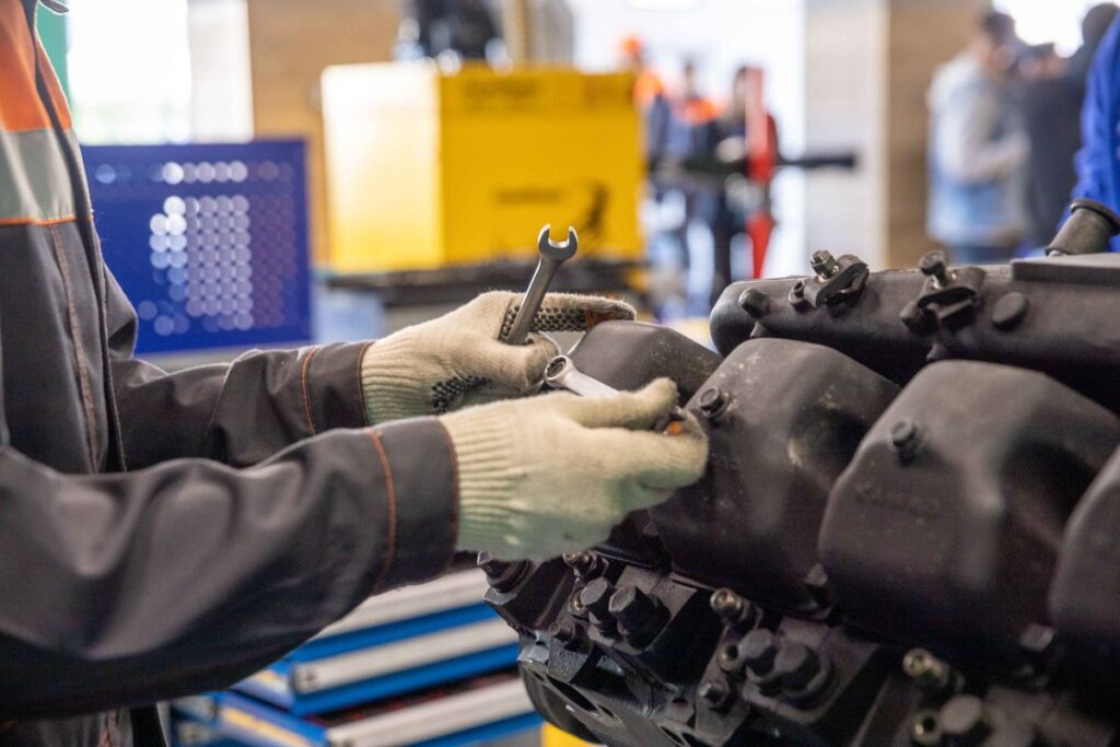 Gloved hands working on an engine