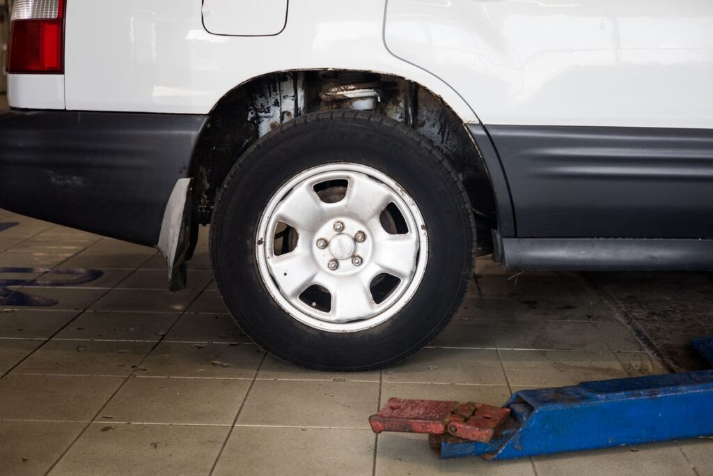 Car wheel raised with a floor jack in a repair shop