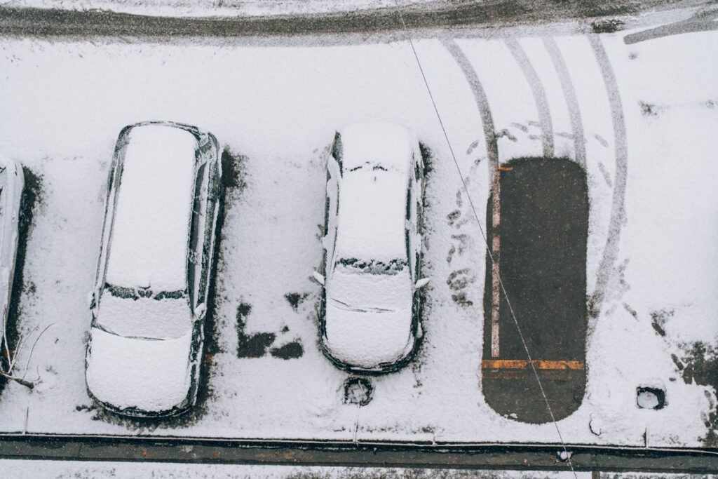 Aerial view of snow-covered cars in a parking lot