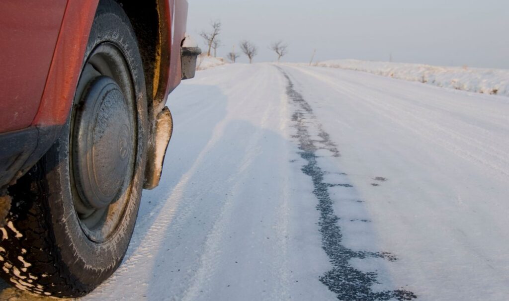 Car tire on a snow-covered winter road
